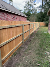 Three-rail cedar fence along brick home